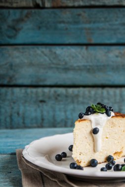 Süzme peynir pişmiş puding, ekşi krema ve yaban mersini 