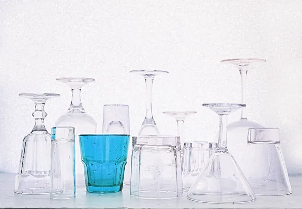 Copos de vidro de diferentes formas e um multi-colorido em um branco — Fotografia de Stock