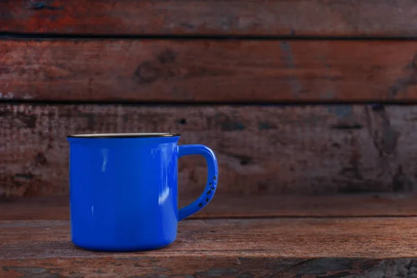 Синя чашка на старому дерев'яному червоному фоні — стокове фото
