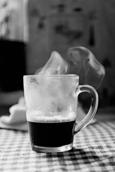 Sweating with steam cup of coffee on a black and white table — Stock Photo, Image
