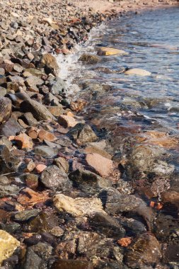 dalgalar kıyıya çakıl taşları ile haddelenmiş