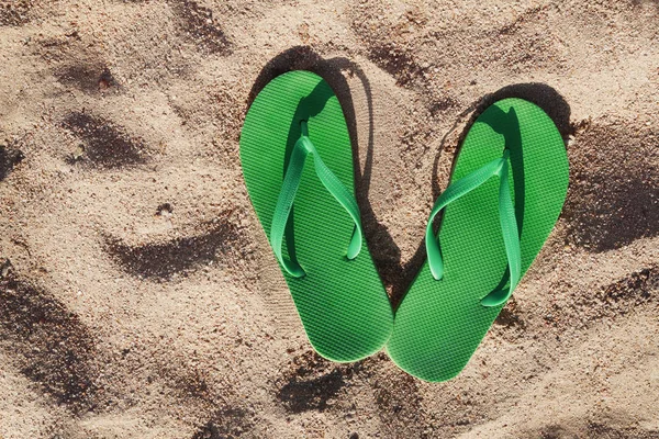 Chanclas verdes en la arena cerca del mar — Foto de Stock