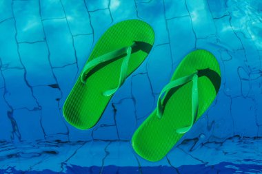 üstten görünüm yüzme havuzunda yüzen yeşil flip flop