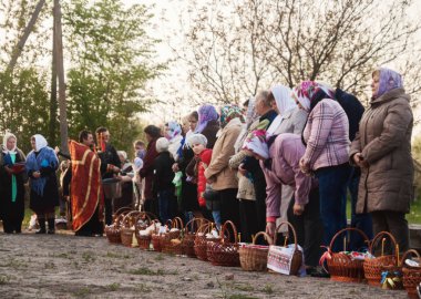 Paskalya'da, rahip sepetleri ve mum insanlarla kutsar.