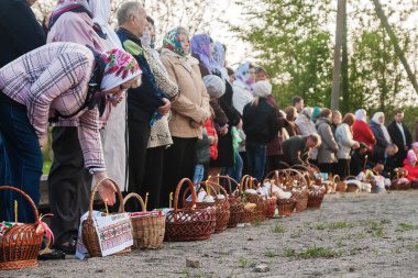 Paskalya'da birçok kişi ayakta üst üste sepetleri ve mum