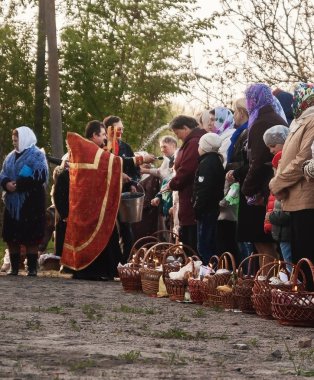Paskalya'da, rahip sepetleri ve mum insanlarla kutsar.