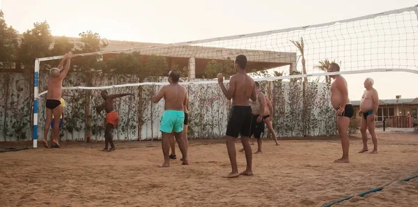 Hommes blancs, arabes, africains jouant au volley-ball sur la plage — Photo