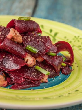 Bir vejetaryen yalın pancar salatası, yeşil üzerinde parlak bir etnik plakadır 