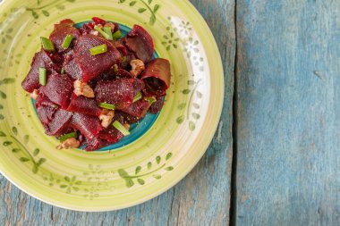 Bir vejetaryen yalın pancar salatası, yeşil üzerinde parlak bir etnik plakadır 