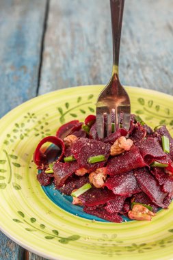 Bir vejetaryen yalın pancar salatası, yeşil üzerinde parlak bir etnik plakadır 