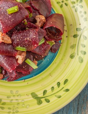 Bir vejetaryen yalın pancar salatası, yeşil üzerinde parlak bir etnik plakadır 