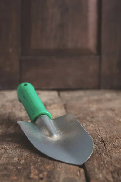Uma ferramenta de jardim, uma pá em uma mesa marrom velha de madeira, close-up. C — Fotografia de Stock
