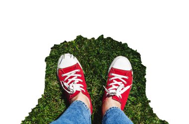 Yeşil çimenlerin üzerinde eski kırmızı spor ayakkabılar bacaklar. Yukarıdan görüntüleyin. Co