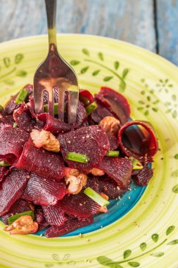 Bir vejetaryen yalın pancar salatası, yeşil üzerinde parlak bir etnik plakadır 