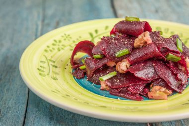 Bir vejetaryen yalın pancar salatası, yeşil üzerinde parlak bir etnik plakadır 