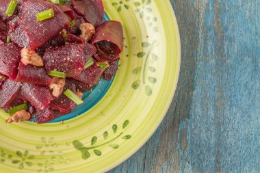 Bir vejetaryen yalın pancar salatası, yeşil üzerinde parlak bir etnik plakadır 