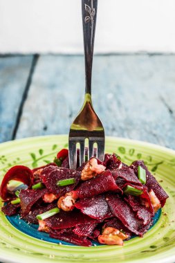 Bir vejetaryen yalın pancar salatası, yeşil üzerinde parlak bir etnik plakadır 