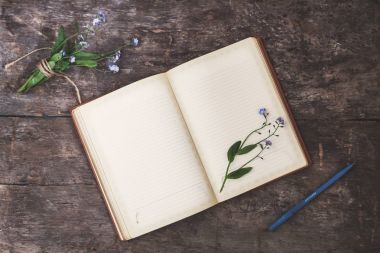 Eski bir defter ve bir buket o eski ahşap arka plan üzerinde yatıyor