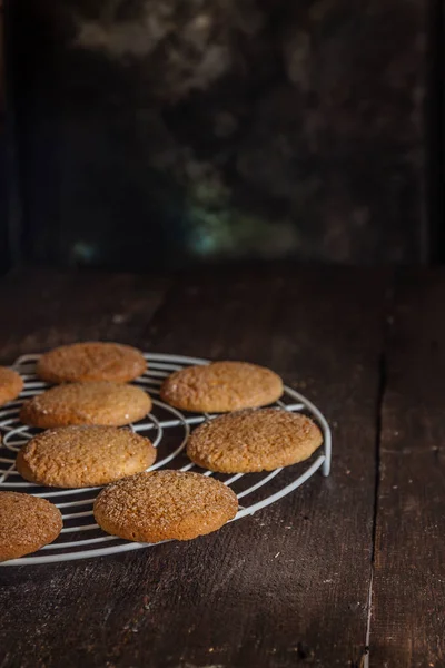 Galletas en una rejilla para hornear sobre un fondo oscuro, estilo retro — Foto de Stock