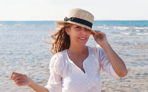 Hararetle karşı bac gülüyor bir hasır şapka, genç bir kadın