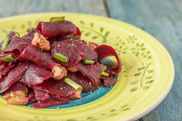 Bir vejetaryen yalın pancar salatası, yeşil üzerinde parlak bir etnik plakadır 