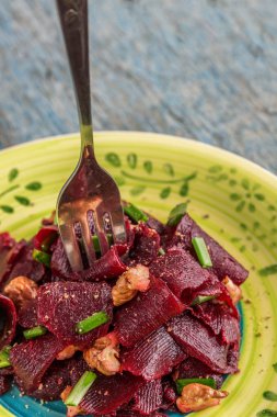 Bir vejetaryen yalın pancar salatası, yeşil üzerinde parlak bir etnik plakadır 