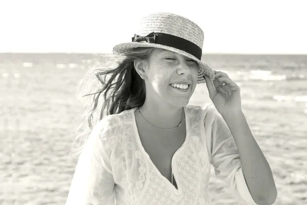 Μια νεαρή γυναίκα με ένα ψάθινο καπέλο, διακαώς γέλιο κατά το bac — Φωτογραφία Αρχείου