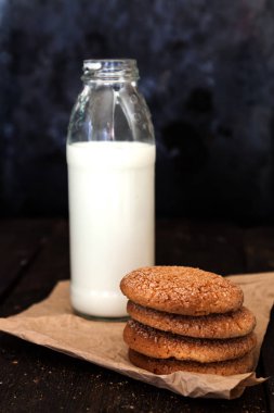 Şişe süt ve bir yığın tanımlama karanlık bir arka plan üzerinde yeniden