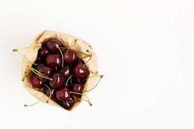 Taze kiraz çilek üzerinde beyaz bir backgro izole bir kağıt torba