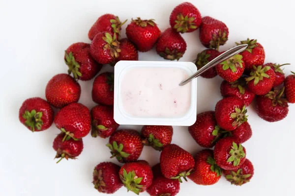 Conteneur avec yaourt et un tas de fraises fraîches sur blanc — Photo