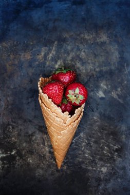 Bir gözleme koni karanlık bir eski backgrou üzerinde taze sulu çilek