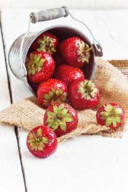 Taze sulu çilek bir kova üzerinde beyaz bir adam döktü.