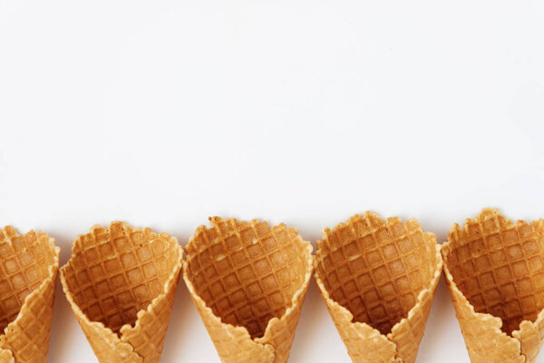 Several waffle cones lined in tower, smile, or even row, top vie