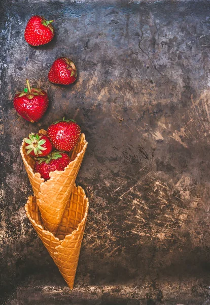 Fresas frescas y jugosas en un cono de gofre sobre un fondo oscuro — Foto de Stock
