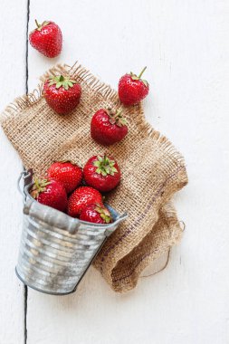 Taze sulu çilek bir kova üzerinde beyaz bir adam döktü.
