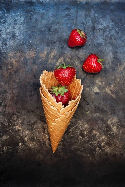 Fresas frescas y jugosas en un cono de gofre sobre un fondo oscuro — Foto de Stock