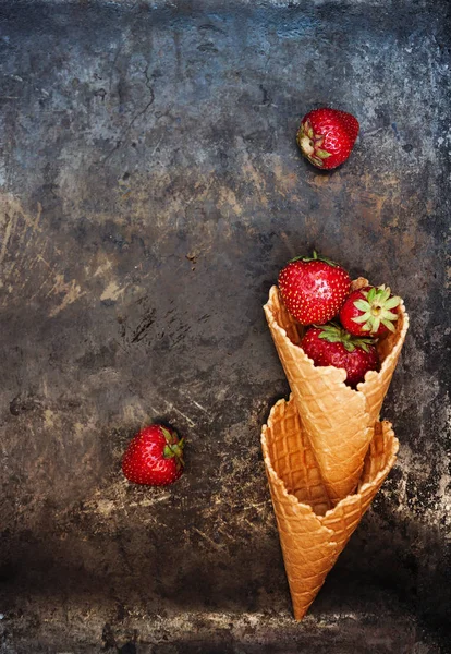 Fresas frescas y jugosas en un cono de gofre sobre un fondo oscuro — Foto de Stock