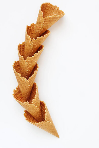 Several waffle cones lined in tower, smile, or even row, top vie