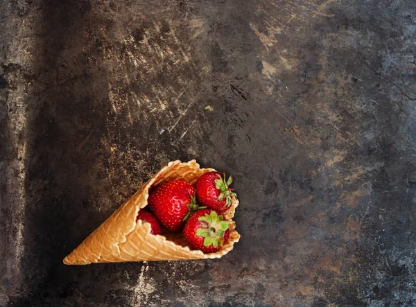 Bir gözleme koni karanlık bir eski backgrou üzerinde taze sulu çilek