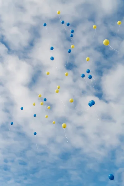 Les ballons multicolores volent dans un ciel bleu clair avec des nuages — Photo