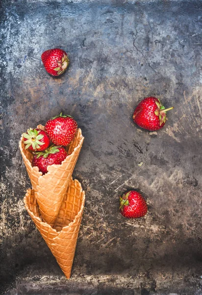 Fresas frescas y jugosas en un cono de gofre sobre un fondo oscuro — Foto de Stock