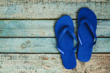 Ahşap bir zemin üzerine mavi kauçuk flip flop