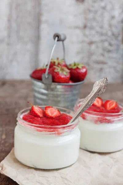 Йогурт з вареним соусом у склянці та відро зі свіжої полуниці — стокове фото
