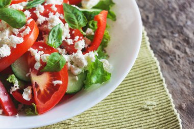 Ahşap arka plan, beyaz bir tabağa Shopska salata yakın çekim