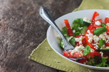 Ahşap arka plan, beyaz bir tabağa Shopska salata yakın çekim