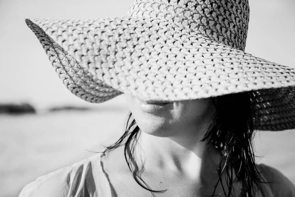 İnci kapsayan geniş ekledi hasır şapkalı güzel genç kadın