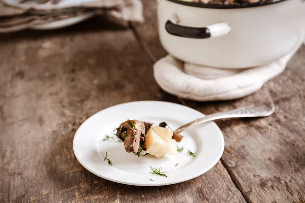 Assiette de pommes de terre aux champignons sur fond de bois — Photo