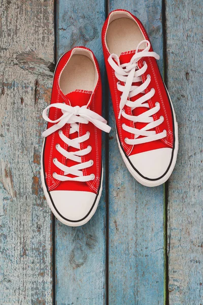 Kırmızı retro spor ayakkabı, mavi ahşap arka plan üzerinde yakın çekim
