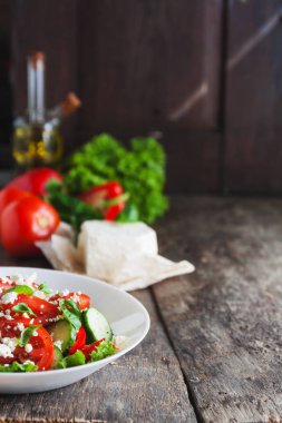 Ahşap arka plan, bir sayı üzerinde beyaz bir tabak içinde Shopska salata 