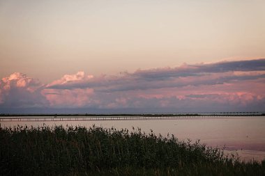 Manzara güzel pembe sunse üzerinde bir deniz örgü uzun köprüden